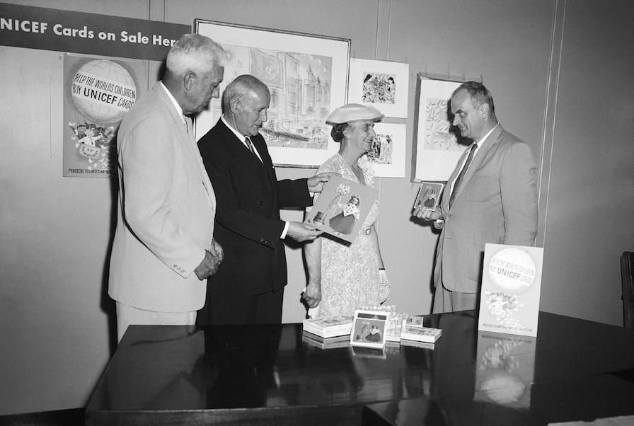UNICEF Executive Director Maurice Pate (left), Prime Minister of Australia Robert Menzies, Mrs. Menzies and UNICEF’s E.J.R. Heyward review the 1958 selection of UNICEF greeting cards.